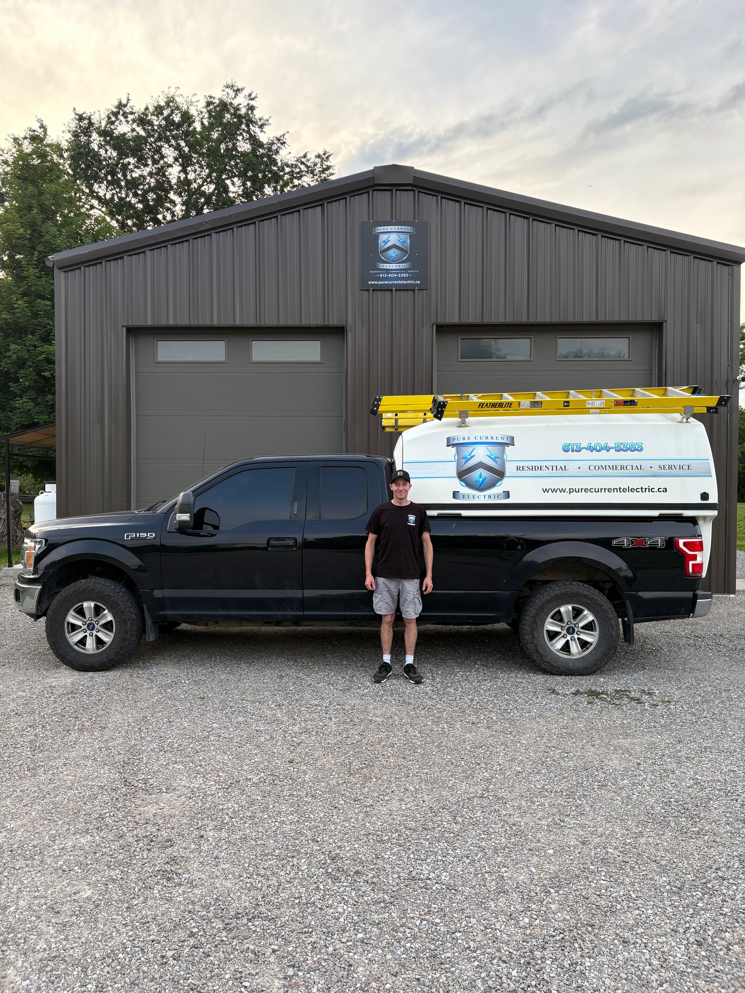 Larry — founder of Pure Current Electric — standing beside the company truck